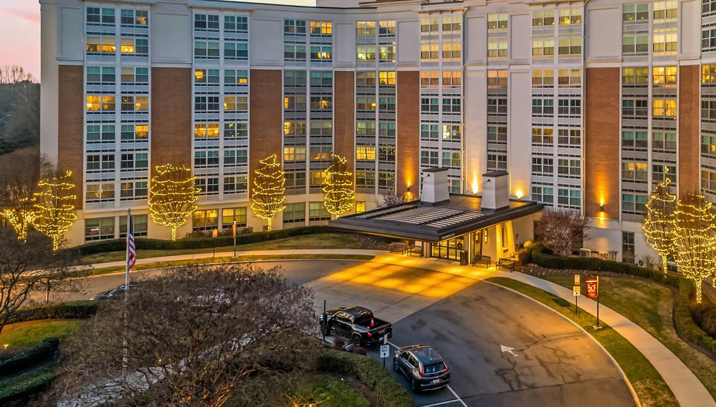 Warm white holiday lighting framing a brick front entrance at dusk